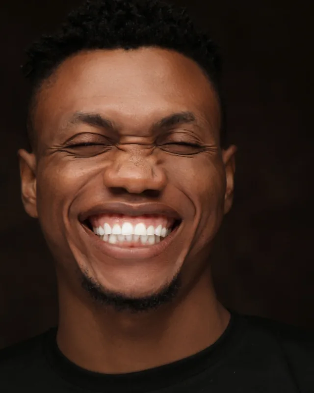 Man laughing with a wide, natural smile